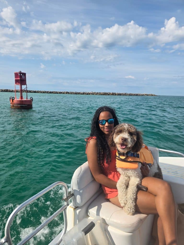 Woman and her dog enjoying a sunny boat ride with Flippin' Awesome Adventures, one of the top dog friendly things to do in Panama City Beach.