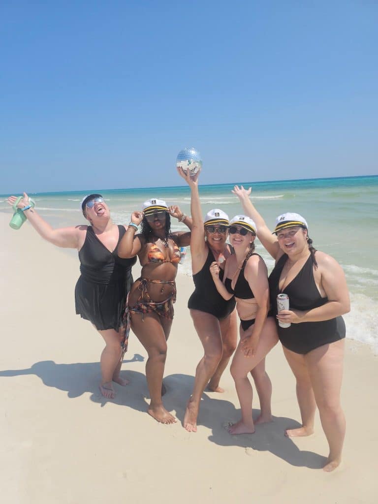Bachelorette party celebrating on the beach in Panama City Beach with captain hats during a girls trip to Florida