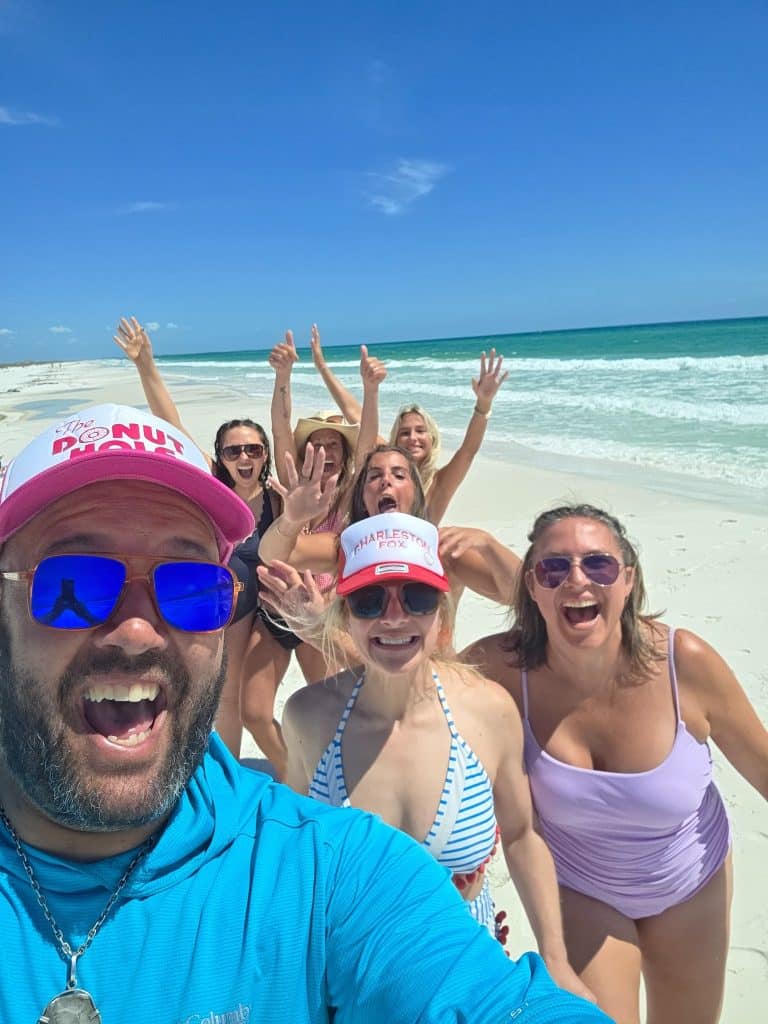Captain and guests taking a fun group selfie on Shell Island beach in Panama City Beach, Florida.