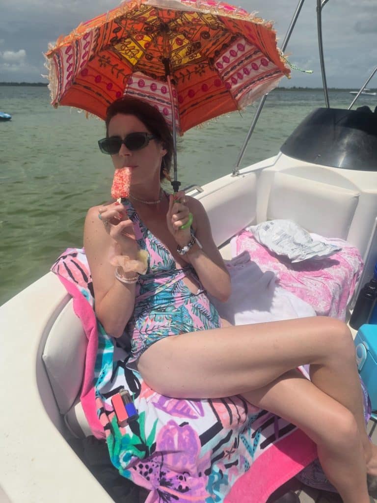Guest relaxing aboard a private boat tour near Shell Island in Panama City Beach while enjoying a frozen treat.